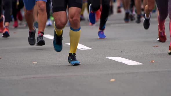 Crowd of People Running in City Marathon. Men and Women Wearing Sportswear. Lower Part of Bodies alt