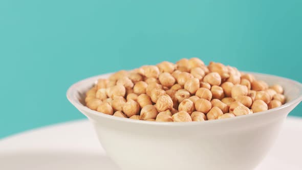 Dry Chickpeas in a White Plate on a Wooden Background