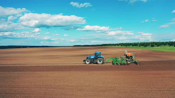 Side View of a Farming Vehicle Seeding the Ground alt