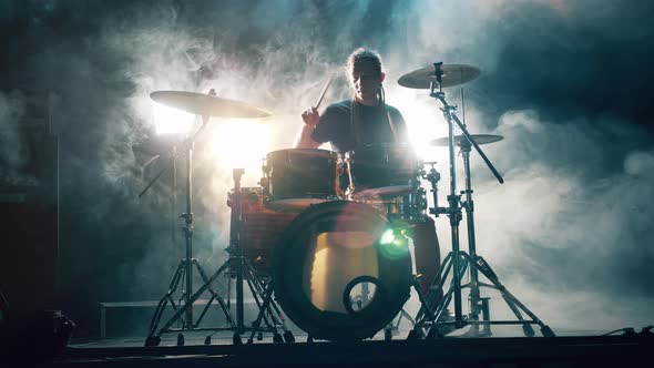 Professional Drummer Is Playing Drums in a Studio Filled with Smoke alt