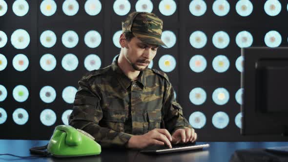 Man in Military Clothes Types on Keyboard Dials Number on Old Telephone Speaks