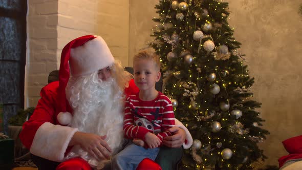 Santa Claus Giving Present for Cute Boy at Christmas