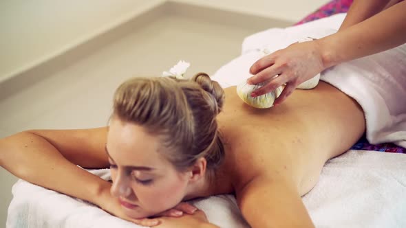 Massage Therapist Using Herbal Compress on Woman alt