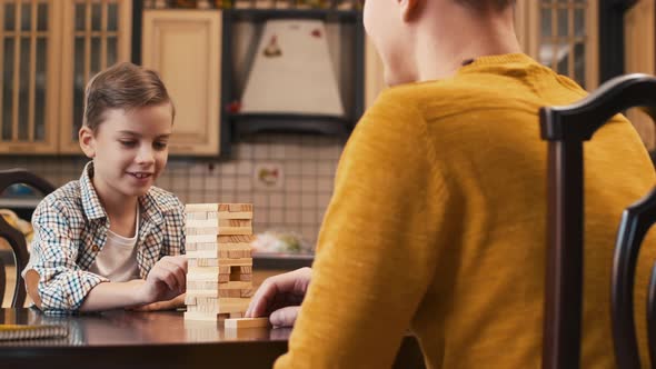 Boy playing Jenga with his father,