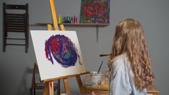 Girl Draws a Picture and Looks at It  alt