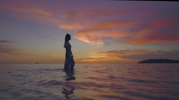 Asian Woman Silhouette Walking Alone in the Sea at Beautiful Sunset Thailand