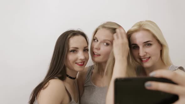 Three Beautiful Women Selflessly Happy with a Smartphone alt