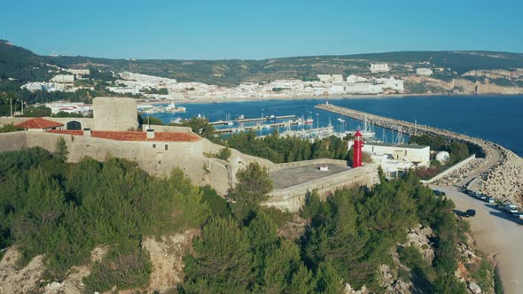 Aerial view of Sesimbra touristic attraction, lighthouse and fortress on hills