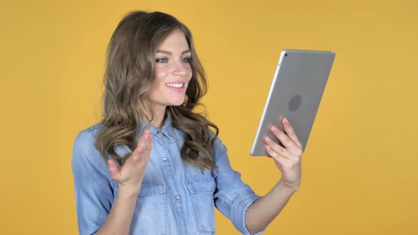 Video Chat By Young Girl Via Tablet Isolated on Yellow Background alt