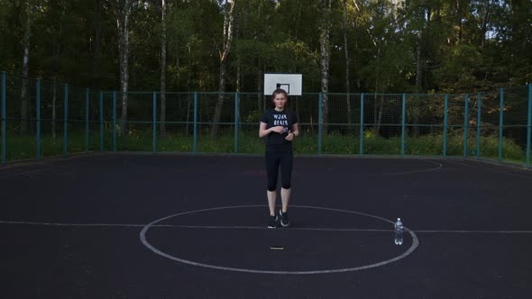 Woman Actively Runs in Place on the Basketball Court Morning Exercises