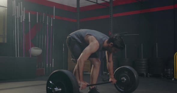 Muscular young Caucasian man exercises working out with lifting weights heavy barbell alt