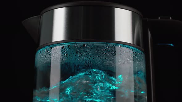 Boiling Water for a Drink Tea and Coffee Into an Electric Glass Kettle with Blue Lights