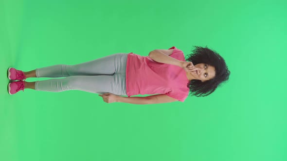 Portrait of Young Female African American Telling Something and Making Hush Gesture Secret alt