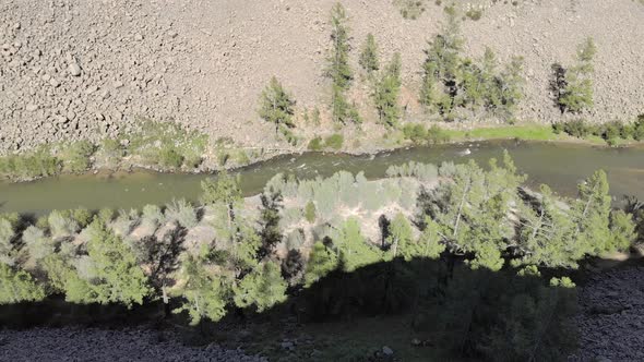 Broken Crumbled Rocks Spilling From the Narrow Canyon Slope Ridge Towards the Deep Valley Floor alt