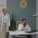 Female Colleague Supporting Emotionally Upset Young Doctor Indoors - VideoHive Item for Sale