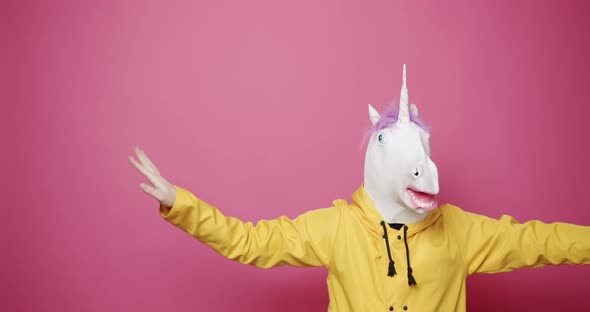 Happy Guy in Yellow Clothes Dance with Unicorn Mask alt