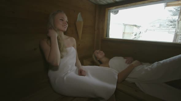 Two young women relaxing in sauna