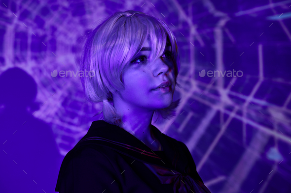 portrait of young anime style woman in blonde wig in blue neon light on ...