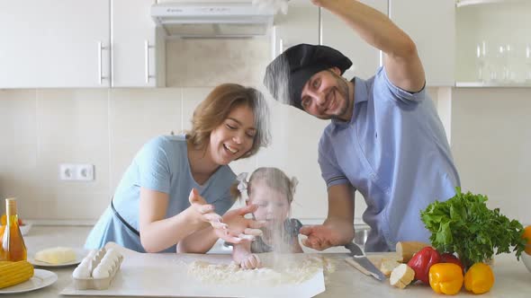 Happy Family Is Cooking in The Kitchen. Dad Sifts Flour Slow Motion.