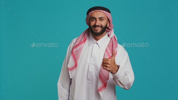 Middle eastern man does thumbs up Stock Photo by DC_Studio