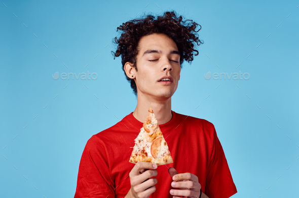 man with a piece of pizza in his hand on a blue background