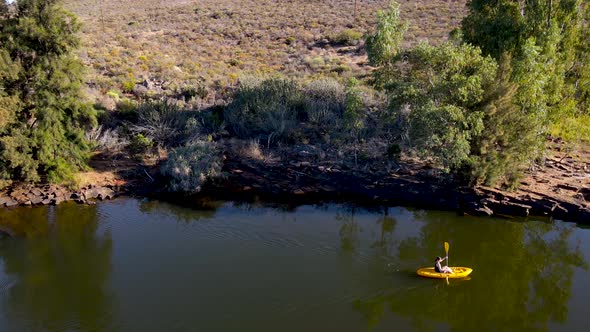 Aerial view woman on yellow kayak, Western Cape, South Africa. alt