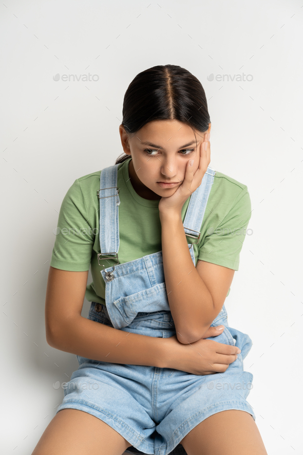 Unhappy teenager having problem, conflict, academic failure sitting on floor thinking on solution
