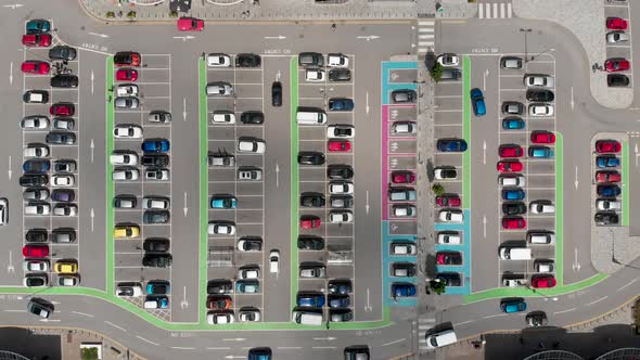 Aerial footage of a busy car park with cars  parking and driving around the car park