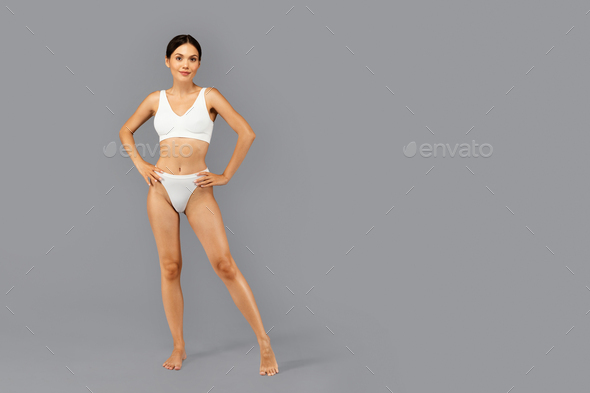 Smiling confident european slim millennial lady in white underwear enjoy perfect body care