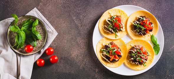 Smash Burger Tacos with sauce, tomatoes and basil on a plate top view web banner