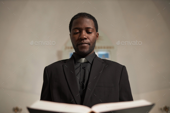 African American Man as Priest Speaking in Church