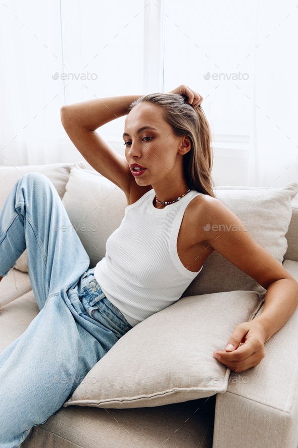young pretty girl in a white tank top and blue jeans Stock Photo