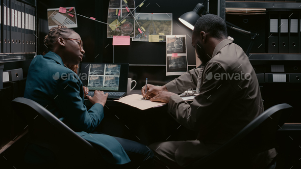 Two police officers analyzing surveillance footage