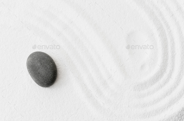 Zen Stone in Japanese garden with grey rock sea stone on white sand texture background, Yin and Yang