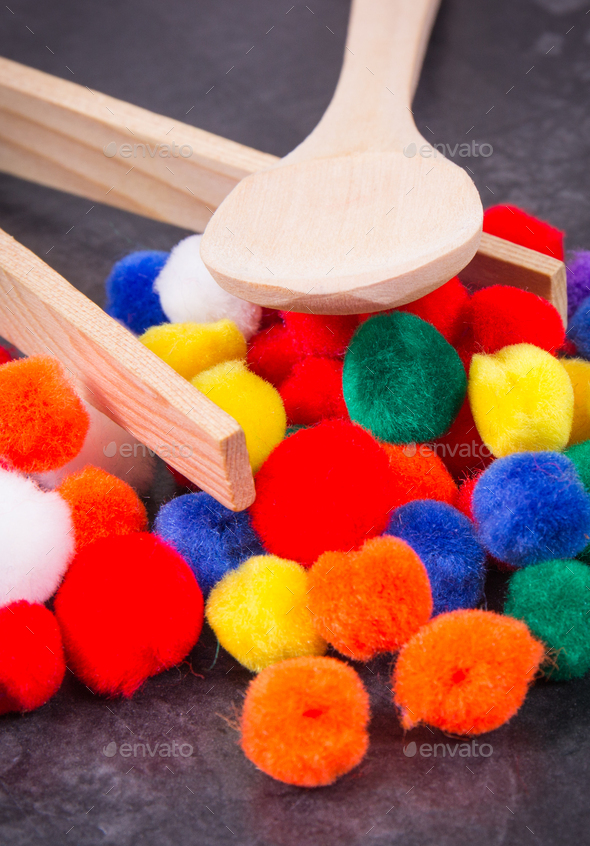 Colorful pompoms with spoon and tongs. Development of kids motor skills ...