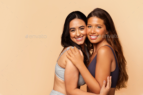 Two diverse positive young women in underwear, hugs, enjoy body care Stock  Photo by Prostock-studio