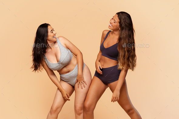 Two joyful diverse young women in underwear engaging in playful dance Stock  Photo by Prostock-studio