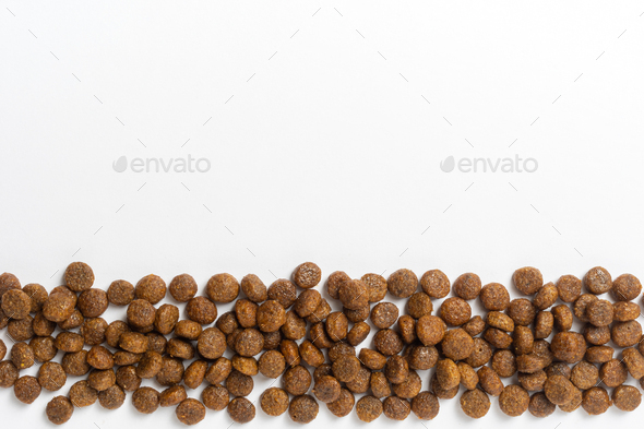 Dry pet food background. Pile of granulated animal feeds on white. Granules of good nutrition