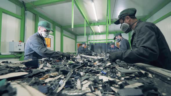 Men Sort Metal Garbage on a Conveyor. Recycle Process, Secondary Use of Plastic. Trash, E-waste alt