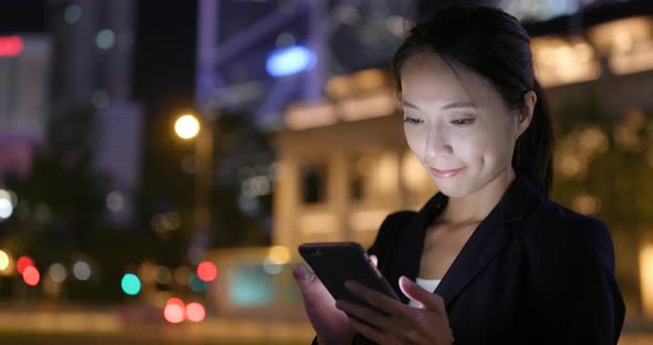 Businesswoman use of cellphone in Hong Kong city  alt