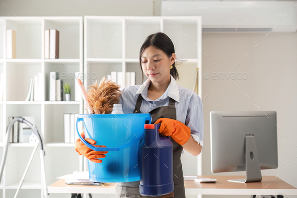 Young woman cleaning to disinfect computer and equipment on office table Cleaning staff or maid