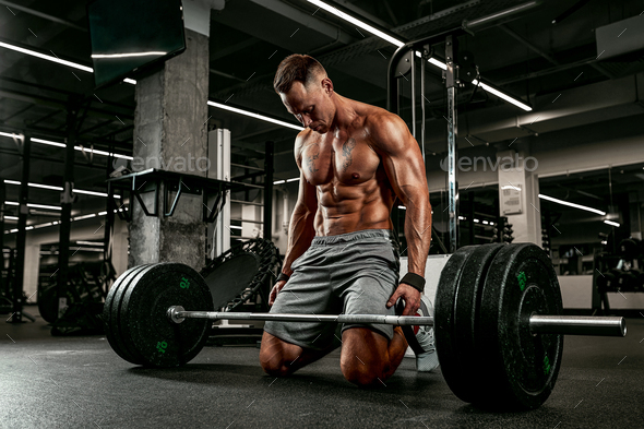 Injury athlete with a barbell preparing for a workout in the gym for ...