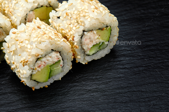 Traditional delicious fresh sushi roll set on a black background