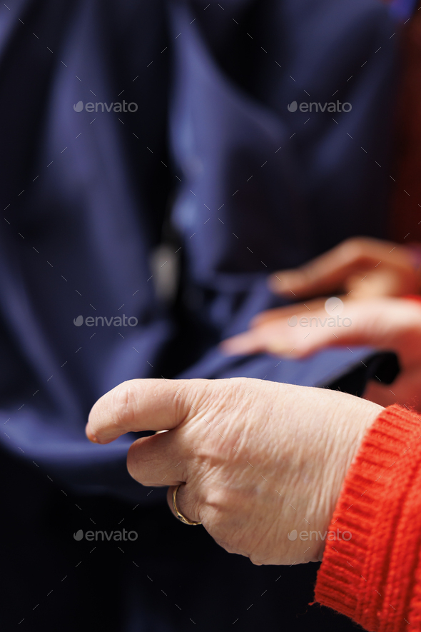 Old woman examining jacket fabric
