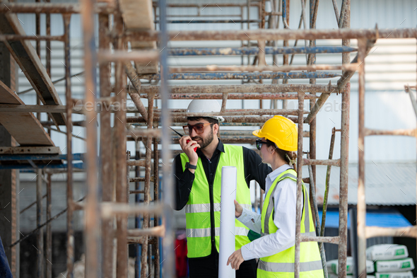 Engineer and architect working on the construction site, double-checking plans and process. - Stock Photo - Images