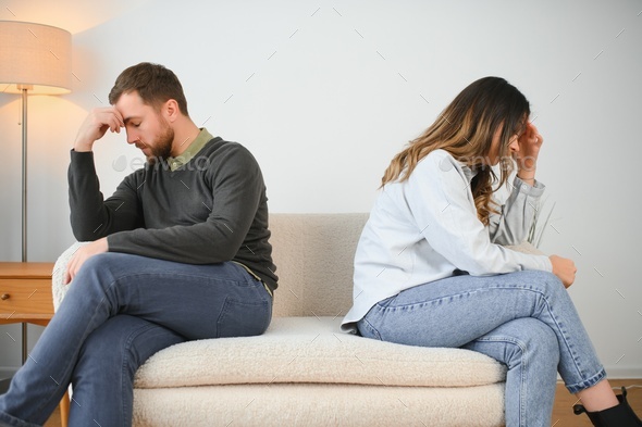 Man and woman feeling stressed and angry at each other, frustrated couple sitting back to back