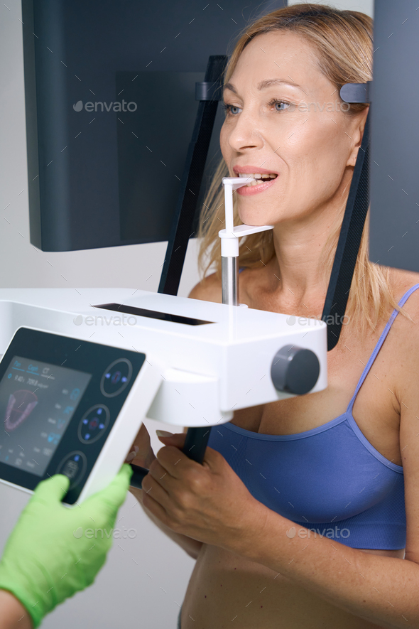 Female patient receiving orthopantomography on modern dental equipment