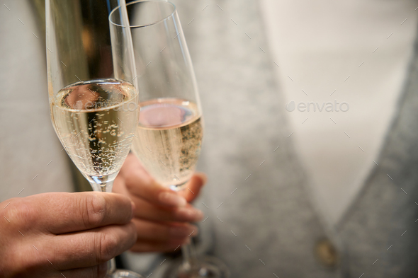 Close Up Glasses Of Clinking Glasses Of Champagne With Lighting