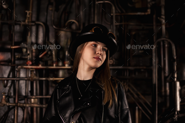 Pretty teen girl model in steampunk image in black leather jacket and top hat