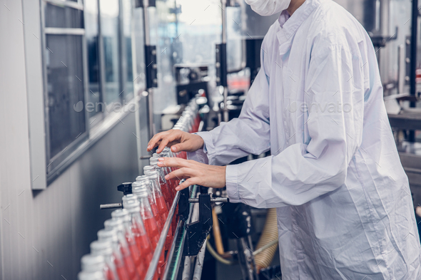food and drink industry staff worker working at conveyor belt production line machine in beverage